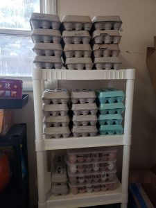 chicken cartons full off eggs stacked on a shelf