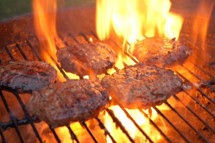 Hamburgers cooking on a grill.