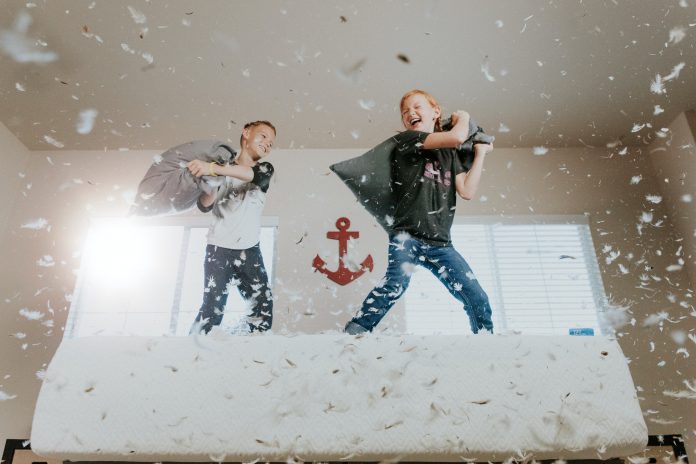 Two children having a pillow fight.