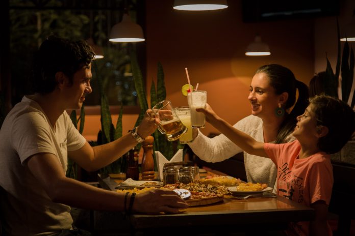 A group of two adults and a child make a toast.