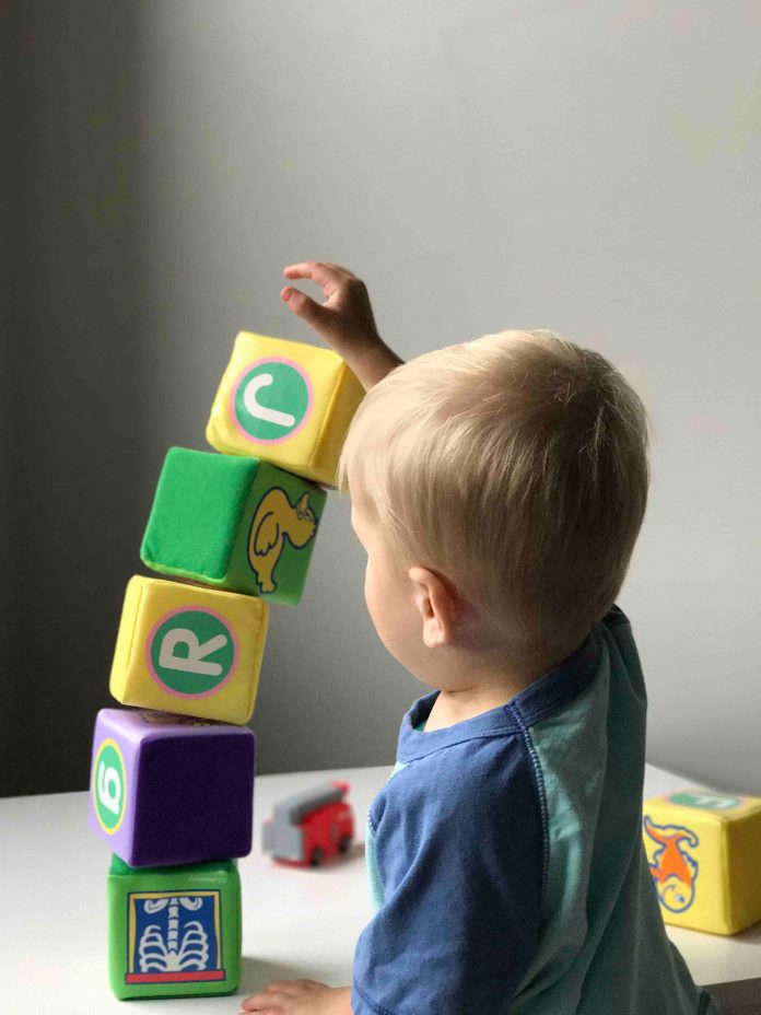 A young boy is stacking blocks.